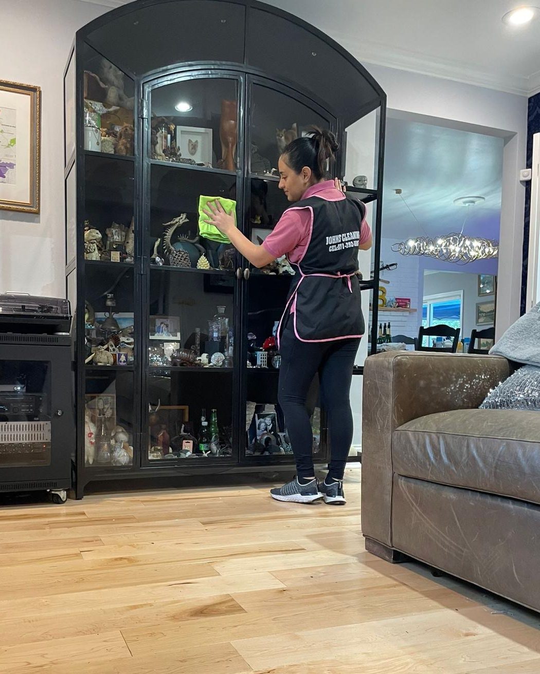 Beberlin Sandoval, owner, cleaning a glass display cabinet