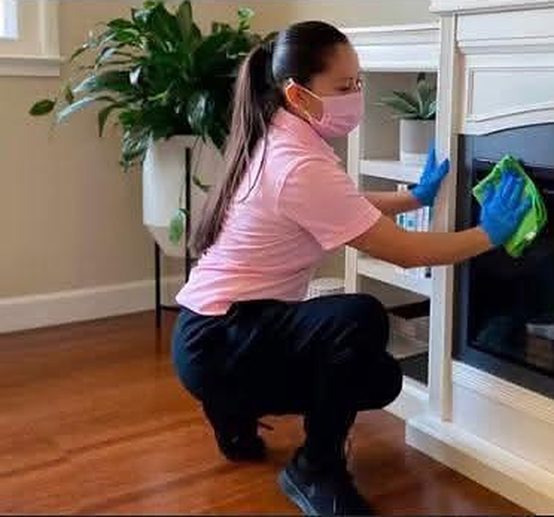 Jhon's Cleaning team member wiping a fireplace